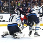 Apr 4, 2026; Columbus, Ohio, USA; Winnipeg Jets goalie Connor Hellebuyck (37) makes a save through the screen of Columbus Blue Jackets right wing Conor Garland (83) during the second period at Nationwide Arena.