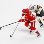 Mar 4, 2026; Detroit, Michigan, USA; Detroit Red Wings center Dylan Larkin (71) skates with the puck chased by Vegas Golden Knights left wing Ivan Barbashev (49) in the first period at Little Caesars Arena.
