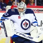 Oct 4, 2024; Calgary, Alberta, CAN; Winnipeg Jets goaltender Connor Hellebuyck (37) makes a save against the Calgary Flames during the second period at Scotiabank Saddledome.