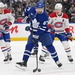 Sep 26, 2024; Toronto, Ontario, CAN; Toronto Maple Leafs forward Max Pacioretty (67) deflects a shot as Montreal Canadiens defenseman David Reinbacher (64) and forward Christian Dvorak (28) look on in the first period at Scotiabank Arena.