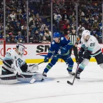 Feb 21, 2022; Vancouver, British Columbia, CAN; Vancouver Canucks forward Brock Boeser (6) and Seattle Kraken defenseman Carson Soucy (28) look on as goalie Chris Driedger (60) makes a save in the third period at Rogers Arena. Canucks won 5-2.