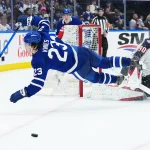 Apr 5, 2025; Toronto, Ontario, CAN; Toronto Maple Leafs left wing Matthew Knies (23) battles for the puck with Columbus Blue Jackets goaltender Elvis Merzlikins (90) during the third period at Scotiabank Arena. Mandatory Credit: Nick Turchiaro-Imagn Images