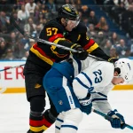 Jan 31, 2026; Vancouver, British Columbia, CAN; Vancouver Canucks defenseman Tyler Myers (57) checks Toronto Maple Leafs forward Matthew Knies (23) in the first period at Rogers Arena.