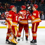 Sep 22, 2026; Calgary, Alberta, CAN; Calgary Flames goaltender Dustin Wolf (32) celebrates win with teammates after defeating Vancouver Canucks at Scotiabank Saddledome.