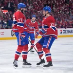 10 mai 2026 ; Montréal, Québec, Canada ; le défenseur des Canadiens de Montréal Lane Hutson (48) observe ses coéquipiers, l\'attaquant Kirby Dach (77) et le défenseur Kaiden Guhle (21), célébrer le but marqué par Dach contre les Sabres de Buffalo durant la troisième période du troisième match de la deuxième ronde des séries éliminatoires de la Coupe Stanley 2026, au Centre Bell.