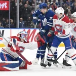 Dec 6, 2025; Toronto, Ontario, CAN; Montreal Canadiens goalie Jakub Dobes (75) makes a glove save as defenseman Noah Dobson (53) covers Toronto Maple Leafs forward Matthew Knies (23) in the first period at Scotiabank Arena.