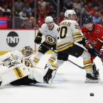 Oct 8, 2025; Washington, District of Columbia, USA; Boston Bruins defenseman Henri Jokiharju (20) and Washington Capitals right wing Brandon Duhaime (22) battle for the puck in front of Bruins goaltender Jeremy Swayman (1) during the third period at Capital One Arena.