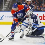 Oct 9, 2024; Edmonton, Alberta, CAN; Edmonton Oilers forward Zach Hyman (18) tries to knock a rebound past Winnipeg Jets goaltender Connor Hellebuyck (37) during the third period at Rogers Place.