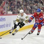 11 novembre 2023; Montréal, Québec, Canada; L'attaquant des Bruins de Boston, Matthew Poitras (51), contrôle la rondelle tandis que l'attaquant des Canadiens de Montréal, Nick Suzuki (14), défend durant la deuxième période au Centre Bell.