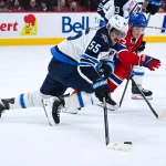 Dec 3, 2025; Montreal, Quebec, CAN; Winnipeg Jets center Mark Scheifele (55) defends the puck against Montreal Canadiens right wing Cole Caufield (13) during the first period at Bell Centre.