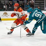 Oct 1, 2025; San Jose, California, USA; San Jose Sharks right wing Carl Grundstrom (91) shoots the puck against Anaheim Ducks defenseman Tristan Luneau (67) during the second period at SAP Center at San Jose.