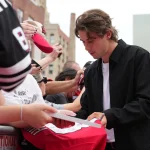 ESPN reporter humiliates herself with tasteless Jack Hughes joke Oct 1, 2026; Newark, New Jersey, USA; New Jersey Devils center Jack Hughes (86) signs autographs for fans prior to the start of their game against the Philadelphia Flyers at Prudential Center.