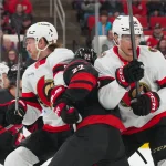 Feb 3, 2026; Raleigh, North Carolina, USA; Ottawa Senators defenseman Jake Sanderson (85) and center Shane Pinto (12) check Carolina Hurricanes center Logan Stankoven (22) during the first period at Lenovo Center.