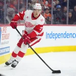 Apr 2, 2026; Philadelphia, Pennsylvania, USA; Detroit Red Wings defenseman Simon Edvinsson (77) controls the puck against the Philadelphia Flyers in the second period at Xfinity Mobile Arena.