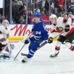 Oct 3, 2026; Toronto, Ontario, CAN; Toronto Maple Leafs center Auston Matthews (34) and Ottawa Senators defenseman Carter Yakemchuk (26) look for the puck during the third period at Scotiabank Arena.