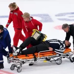 Scary moment on the ice as a linesman is stretchered off after being struck by a puck