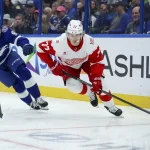 Apr 13, 2026; Tampa, Florida, USA; Detroit Red Wings defenseman Simon Edvinsson (77) controls the puck against the Tampa Bay Lightning in the first period at Benchmark International Arena.