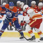 Sep 26, 2026; Edmonton, Alberta, CAN; Edmonton Oilers forward Leon Draisaitl (29) tries to move the puck past Calgary Flames defensemen Zach Whitecloud (28) during the first period at Rogers Place.