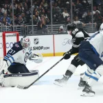 Nov 4, 2025; Los Angeles, California, USA; Winnipeg Jets goaltender Connor Hellebuyck (37) blocks a shot by Los Angeles Kings left wing Andrei Kuzmenko (96) during the second period at Crypto.com Arena.