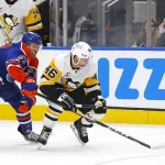 Jan 22, 2026; Edmonton, Alberta, CAN; Edmonton Oilers forward Connor McDavid (97) tries to knock the puck away from Pittsburgh Penguins forward Blake Lizotte (46) during the second period at Rogers Place.