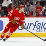 Mar 28, 2026; Detroit, Michigan, USA; Detroit Red Wings defenseman Simon Edvinsson (77) skates with the puck in the first period against the Philadelphia Flyers at Little Caesars Arena.