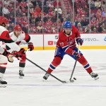 Oct 6, 2026; Montreal, Quebec, CAN; Montreal Canadiens forward Kirby Dach (77) plays the puck and Carolina Hurricanes defenseman K'Andre Miller (19) defends during the first period at the Bell Centre.