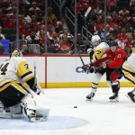 Apr 12, 2026; Washington, District of Columbia, USA; Washington Capitals left wing Aliaksei Protas (21) battle for the puck with Pittsburgh Penguins defenseman Ilya Solovyov (7) and Penguins defenseman Jack St. Ivany (3) in from t of Penguins goaltender Stuart Skinner (74) during the third period at Capital One Arena. Mandatory Credit: Geoff Burke-Imagn Images