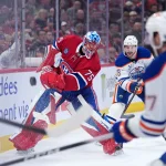 Dec 14, 2025; Montreal, Quebec, CAN; Montreal Canadiens goalie Jakub Dobes (75) clears the puck under pressure from Edmonton Oilers forward Zach Hyman (18) and forward Connor McDavid (97) during the third period at the Bell Centre.