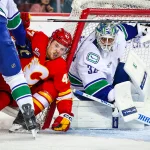 Oct 1, 2025; Calgary, Alberta, CAN; Vancouver Canucks defenseman Tyler Myers (57) and Calgary Flames center Connor Zary (47) battles for the puck in front of Vancouver Canucks goaltender Kevin Lankinen (32) during the second period at Scotiabank Saddledome.