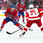 Oct 10, 2026; Montreal, Quebec, CAN; Montreal Canadiens center Alex Newhook (15) plays the puck against Detroit Red Wings center Dylan Larkin (71) during the third period at Bell Centre.