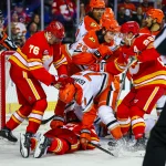 Oct 10, 2026; Calgary, Alberta, CAN; Anaheim Ducks right wing Frank Vatrano (77) checks Calgary Flames left wing Aydar Suniev (61) during the second period at Scotiabank Saddledome.
