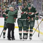 Oct 12, 2026; Saint Paul, Minnesota, USA; Minnesota Wild trainer John Worley tends forward Nico Sturm (78) as forward Michael McCarron (47) helps after he was injured playing the Vegas Golden Knights in the first period at Grand Casino Arena.