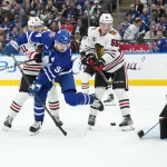 Oct 16, 2023; Toronto, Ontario, CAN; Toronto Maple Leafs center Auston Matthews (34) battles for the puck with Chicago Blackhawks defenceman Kevin Korchinski (55) in front of goaltender Arvid Soderblom (40) during the third period at Scotiabank Arena.