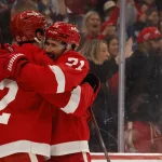 Oct 15, 2026; Detroit, Michigan, USA; Detroit Red Wings defenseman Anton Johansson (42) receives congratulations from center Dylan Larkin (71) after scoring in the second period against the Philadelphia Flyers at Little Caesars Arena.