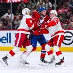 Jan 10, 2026; Montreal, Quebec, CAN; Montreal Canadiens left wing Alexandre Texier (85) gets checked by Detroit Red Wings defenseman Ben Chiarot (8) and defenseman Jacob Bernard-Docker (25) during the first period at Bell Centre.