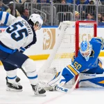 Apr 9, 2026; St. Louis, Missouri, USA; St. Louis Blues goaltender Jordan Binnington (50) defends the net against Winnipeg Jets center Mark Scheifele (55) during the first period at Enterprise Center.