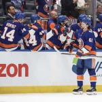 Oct 13, 2026; Elmont, New York, USA; New York Islanders left wing Matias MacCelli (63) celebrates with his teammates after scoring a goal in the first period against the Vancouver Canucks at UBS Arena.
