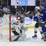 Jan 19, 2026; Toronto, Ontario, CAN; Toronto Maple Leafs forward Auston Matthews (34) plays a puck in the air against Minnesota Wild goaltender Filip Gustavsson (32) and defenseman Quinn Hughes (43) during the first period at Scotiabank Arena.