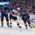 Jan 10, 2026; Denver, Colorado, USA; Columbus Blue Jackets left wing Dmitri Voronkov (10) battles for the puck with Colorado Avalanche defenseman Brent Burns (84) and \left wing Victor Olofsson (95) in the first period at Ball Arena. :