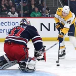Mar 17, 2026; Winnipeg, Manitoba, CAN; Nashville Predators center Fedor Svechkov (40) shoots on Winnipeg Jets goaltender Connor Hellebuyck (37) in the first period at Canada Life Centre.