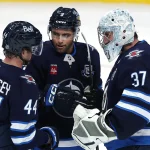 Oct 18, 2025; Winnipeg, Manitoba, CAN; Winnipeg Jets defenseman Josh Morrissey (44), Winnipeg Jets left wing Alex Iafallo (9) and Winnipeg Jets goaltender Connor Hellebuyck (37) celebrate their victory against the Nashville Predators at Canada Life Centre.
