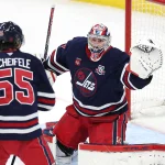 Dec 13, 2025; Winnipeg, Manitoba, CAN; Winnipeg Jets center Mark Scheifele (55) watches a puck go wide of goaltender Connor Hellebuyck (37) in a game against the Washington Capitals in the third period at Canada Life Centre.