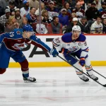 Jan 16, 2025; Denver, Colorado, USA; Colorado Avalanche center Nathan MacKinnon (29) knocks the puck away from Edmonton Oilers center Connor McDavid (97) in the first period at Ball Arena.