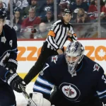 4 novembre 2017 ; Winnipeg, Manitoba, Canada ; le joueur de centre des Jets de Winnipeg, Mark Scheifele (55), récupère un retour devant le gardien des Jets, Connor Hellebuyck (37), durant la troisième période au Bell MTS Centre.