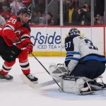 Jan 27, 2026; Newark, New Jersey, USA; Winnipeg Jets goaltender Connor Hellebuyck (37) makes a save on New Jersey Devils right wing Timo Meier (28) during the second period at Prudential Center.