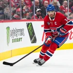 Oct 20, 2026; Montreal, Quebec, CAN; Montreal Canadiens center Nick Suzuki (14) plays the puck against the San Jose Sharks during the second period at Bell Centre.
