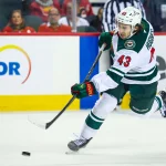 Oct 22, 2026; Calgary, Alberta, CAN; Minnesota Wild defenseman Quinn Hughes (43) shoots the puck against the Calgary Flames during the first period at Scotiabank Saddledome.