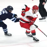 Oct 17, 2026; Winnipeg, Manitoba, CAN; Carolina Hurricanes right wing Andrei Svechnikov (37) is checked by Winnipeg Jets defenseman Jack St. Ivany (6) in the third period at Canada Life Centre.
