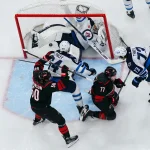 Mar 9, 2025; Raleigh, North Carolina, USA; Carolina Hurricanes center Mark Jankowski (77) scores a goal past Winnipeg Jets goaltender Connor Hellebuyck (37) defenseman Logan Stanley (64) and left wing Brandon Tanev (73) during the second period at Lenovo Center. Mandatory Credit: James Guillory-Imagn Images