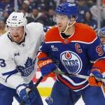 Oct 24, 2026; Edmonton, Alberta, CAN; Edmonton Oilers forward Connor McDavid (97) and Toronto Maple Leafs defensemen Darren Raddysh (43) battle for position during the third period at Rogers Place. Mandatory Credit: Perry Nelson-Imagn Images
